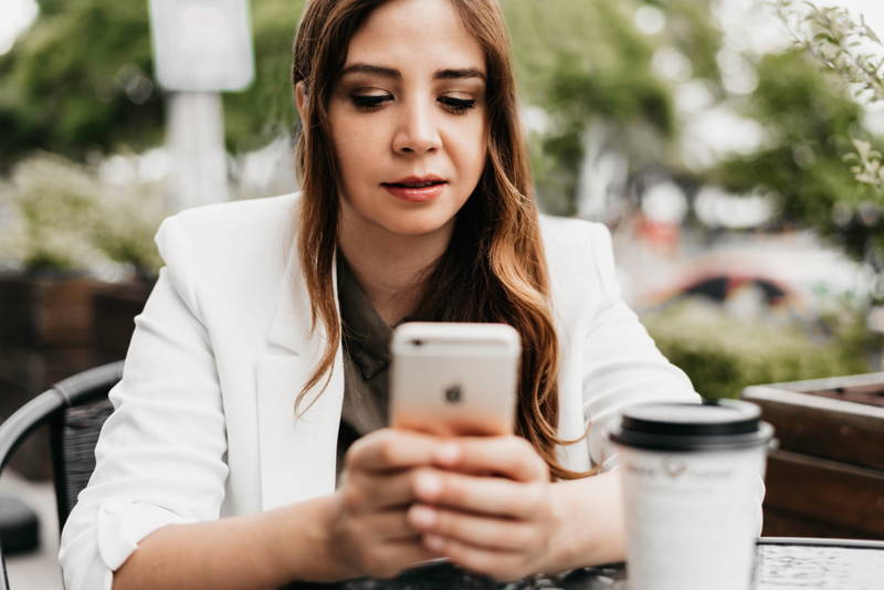 Woman looking at her phone nervously negotiating a new job