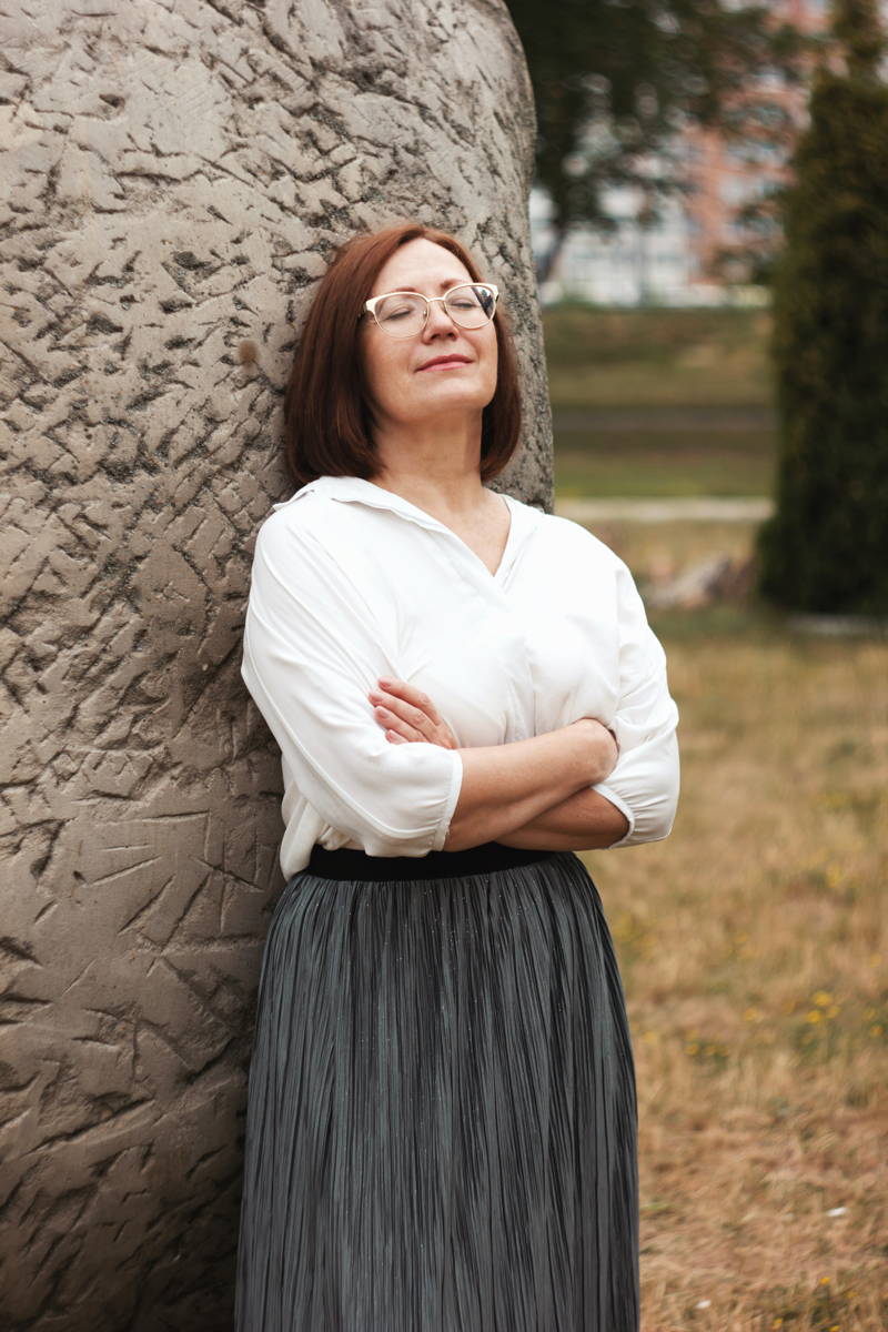 Woman in her mid-50s leaning against a wall