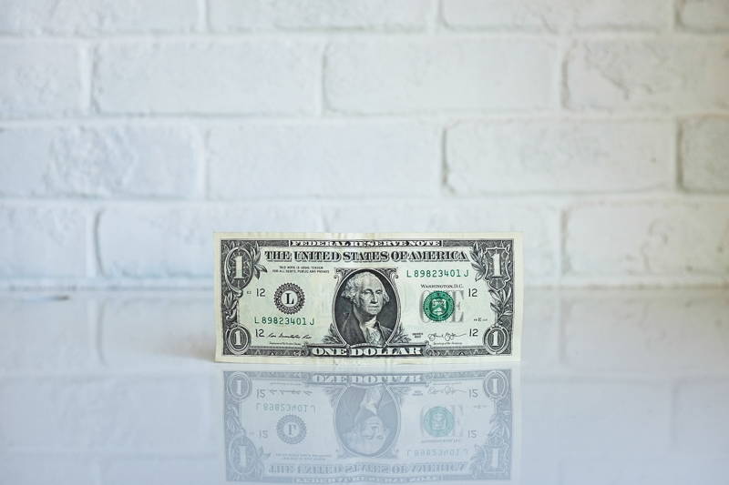 A dollar bill on a table representing asking for a raise