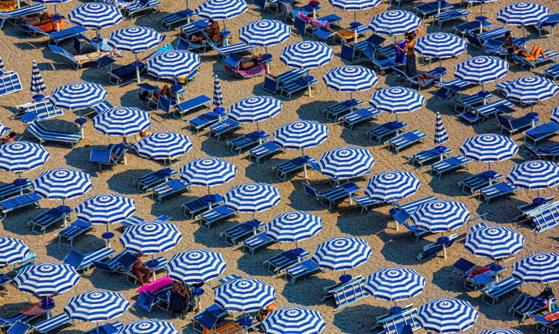 beach filled with same umbrella as people vacation with paid time off