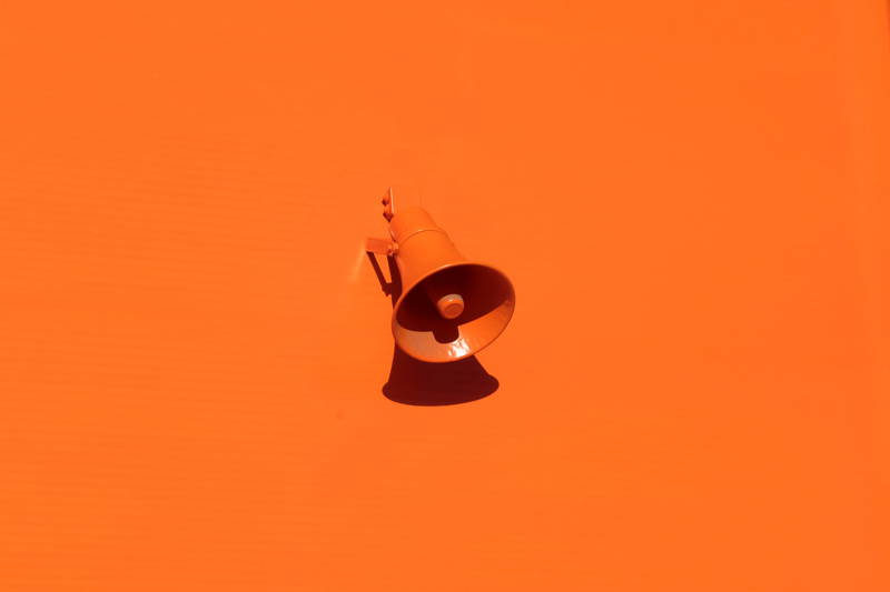 Loudspeaker on a red-orange background