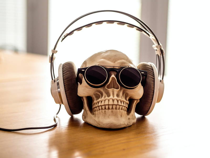 A skull wearing headphones and sunglasses.