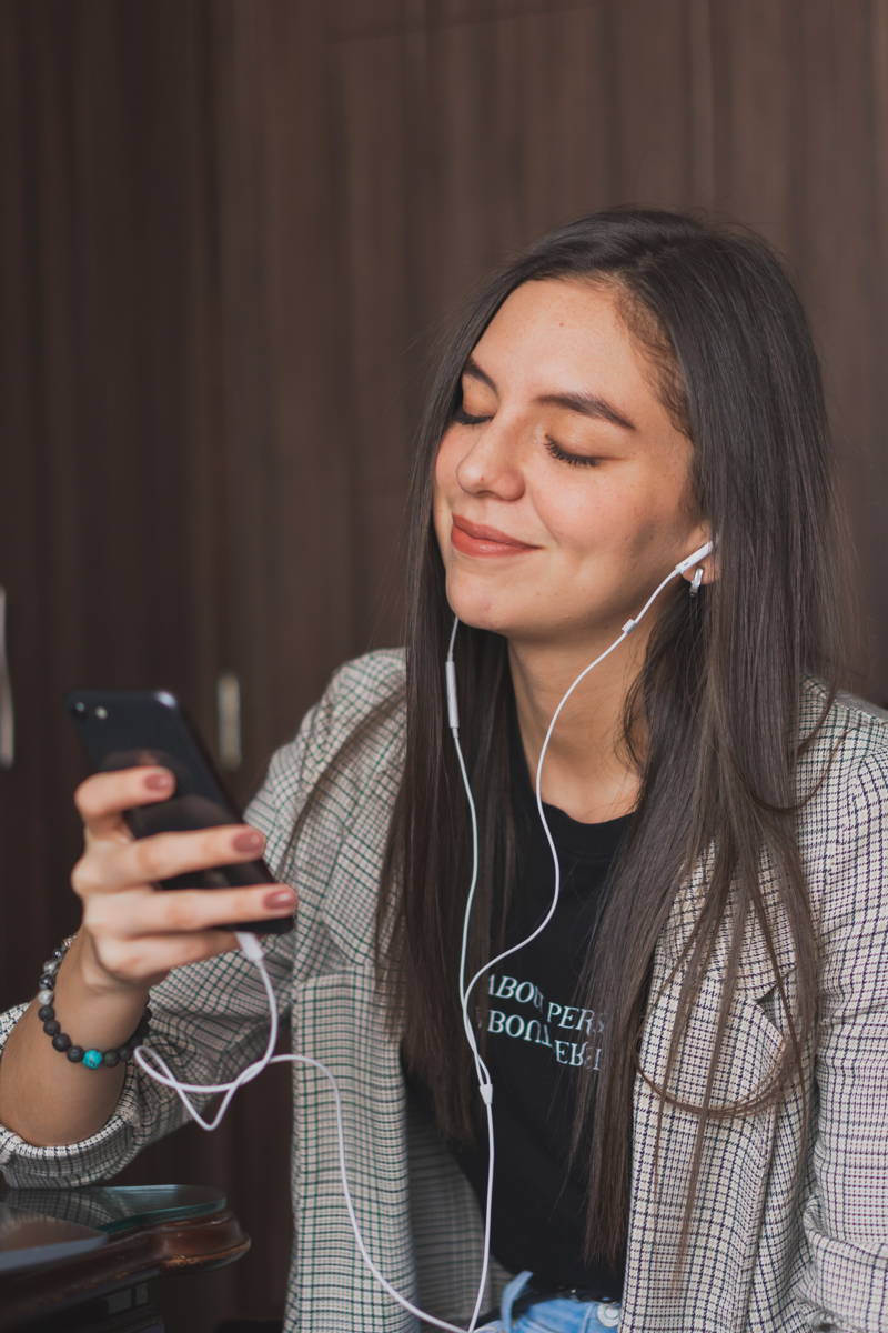 Woman listening to podcast through headphones