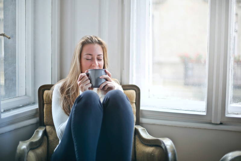 Woman sipping a cup of coffee as an act of self-care