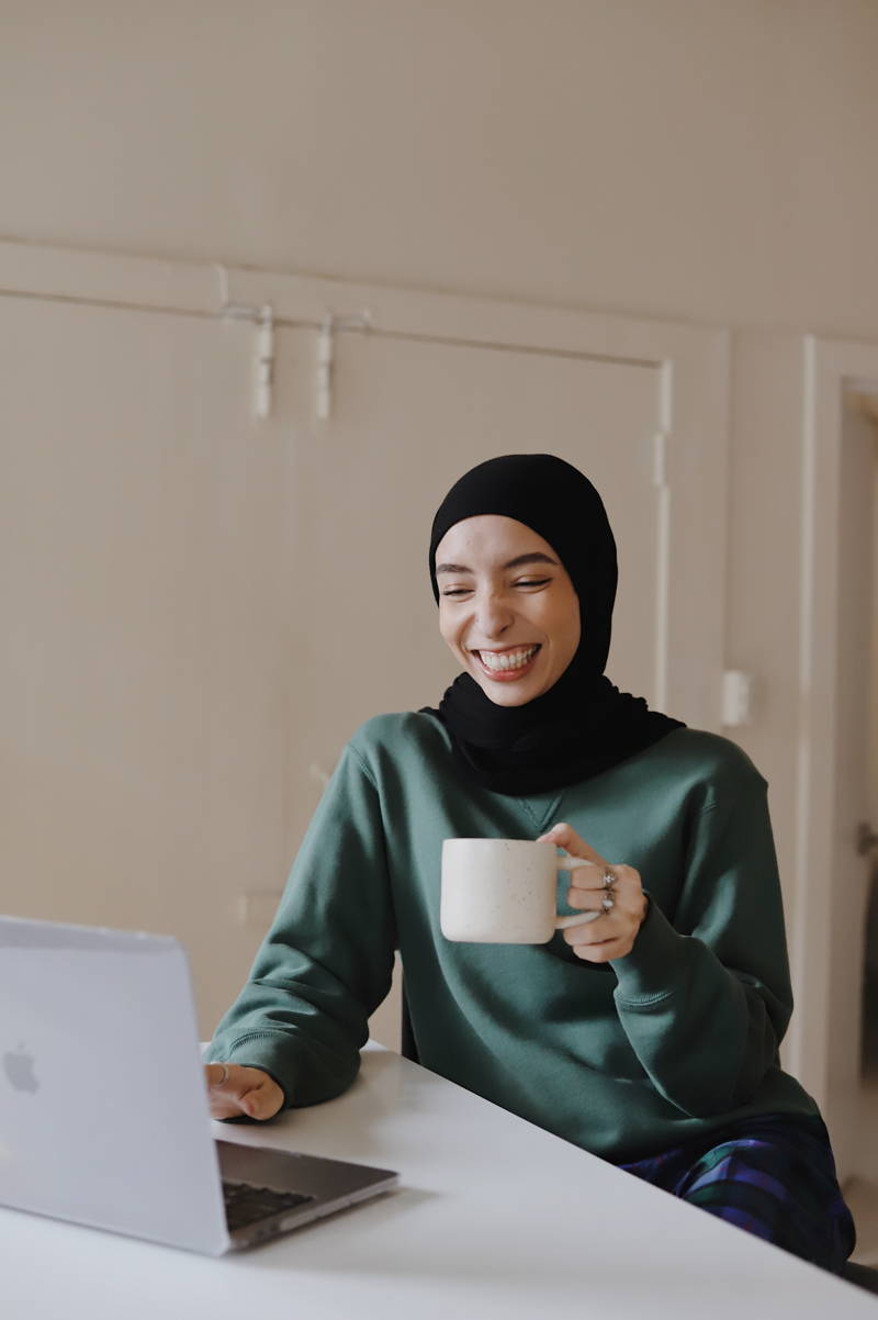 Woman smiling at her computer because she loves her job