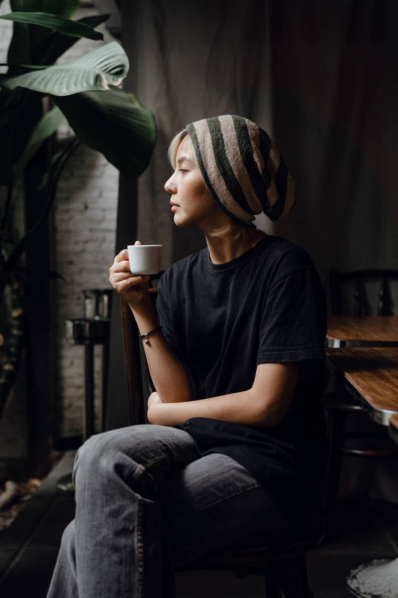 Woman with a beanie on drinking coffee